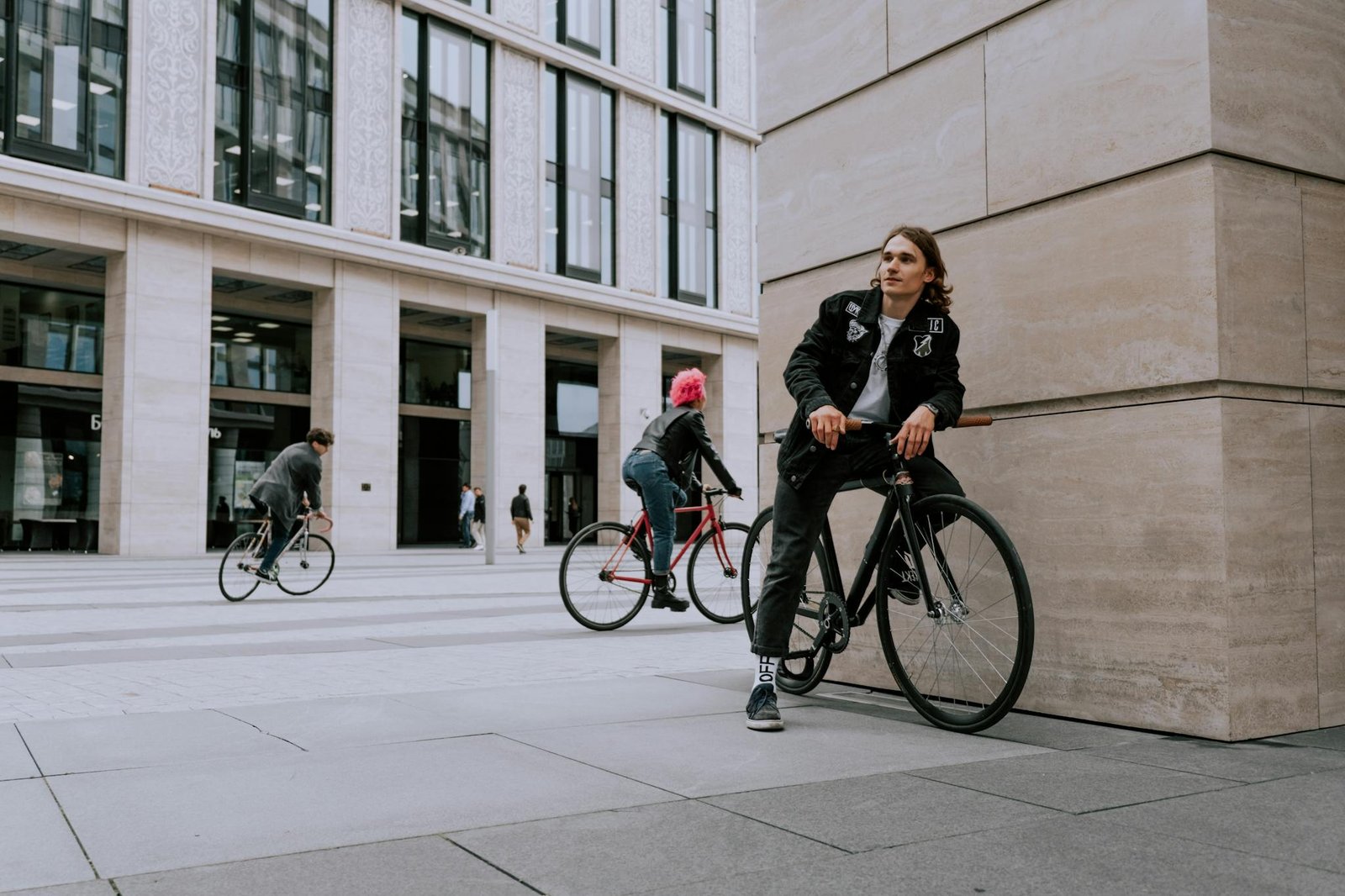 A Man in Black Jacket Riding Black Bicycle